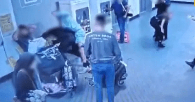 a group of people are standing around a woman in a wheelchair .