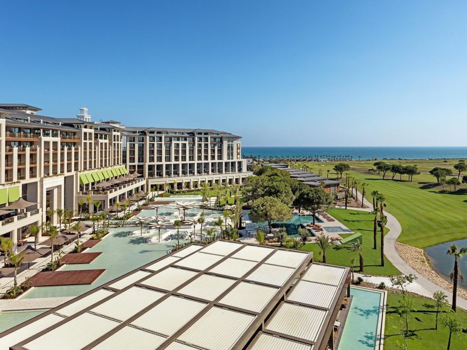 an aerial view of a large hotel with a golf course in the background