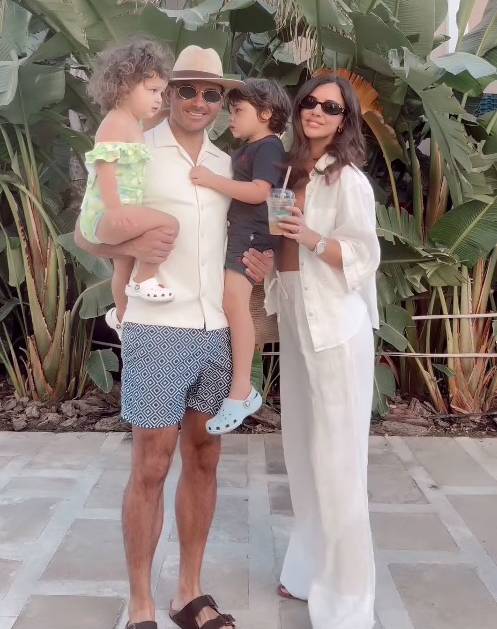 a family posing for a picture with a man wearing a hat