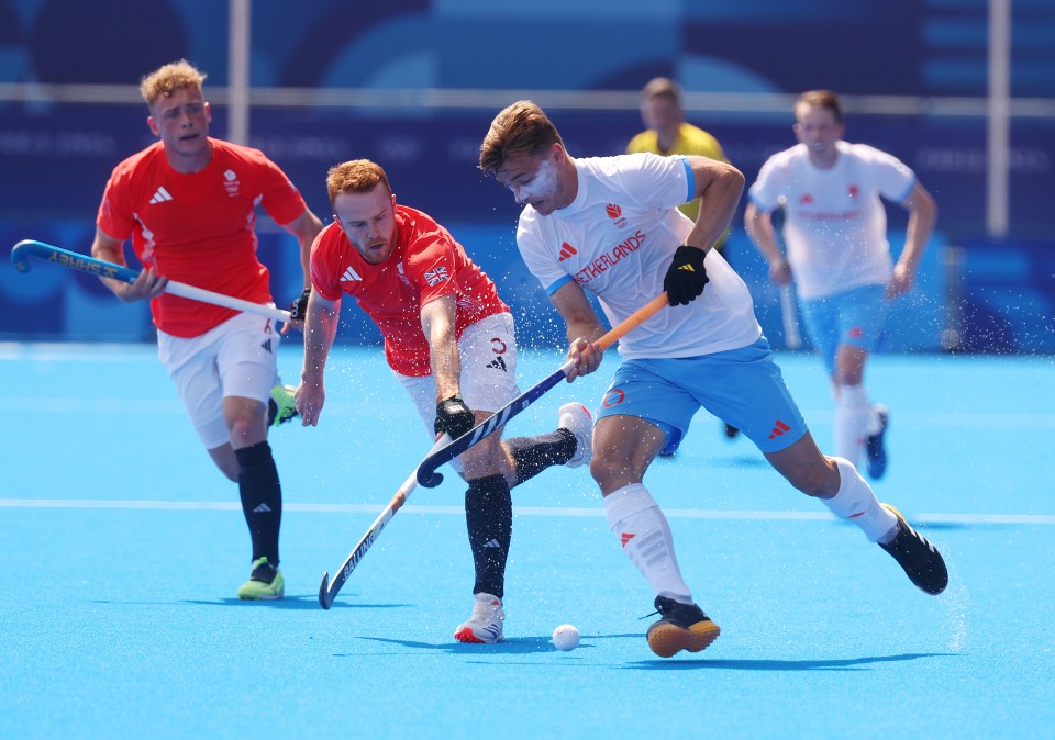 a field hockey game is being played with a player wearing a shirt that says ' british airways ' on it