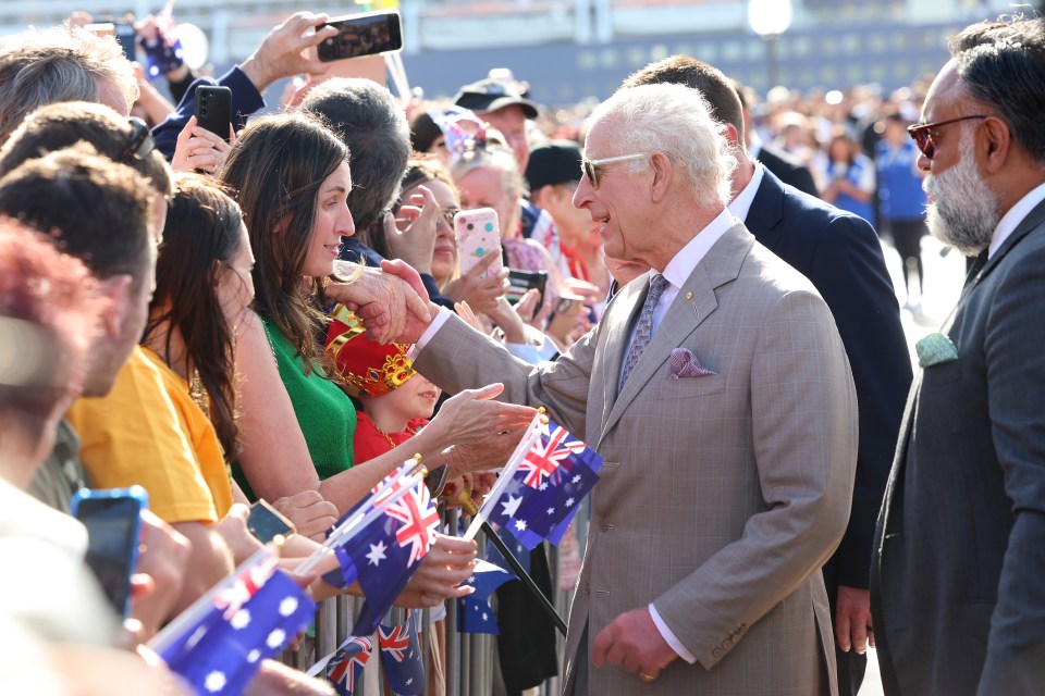 a man in a suit shakes hands with a crowd of people