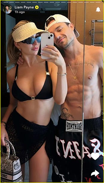 a man and a woman are taking a selfie in front of a mirror .
