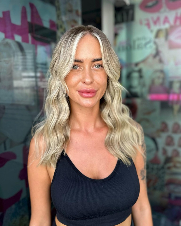 a woman with blonde hair and a black tank top