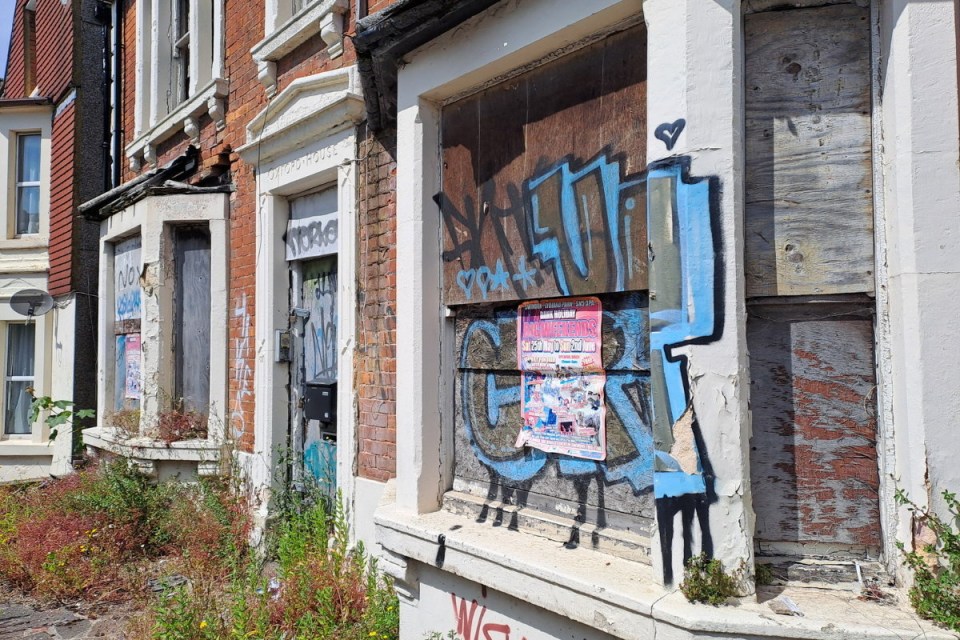 a row of buildings with graffiti on them including one that says ' graffiti ' on it