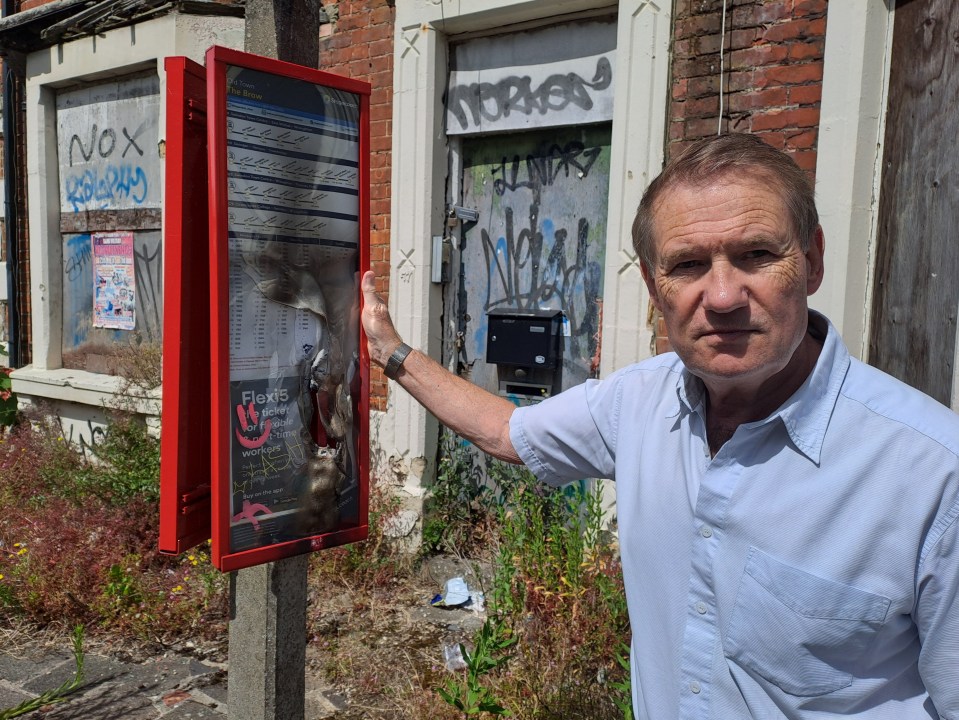 a man stands in front of a sign that says nox
