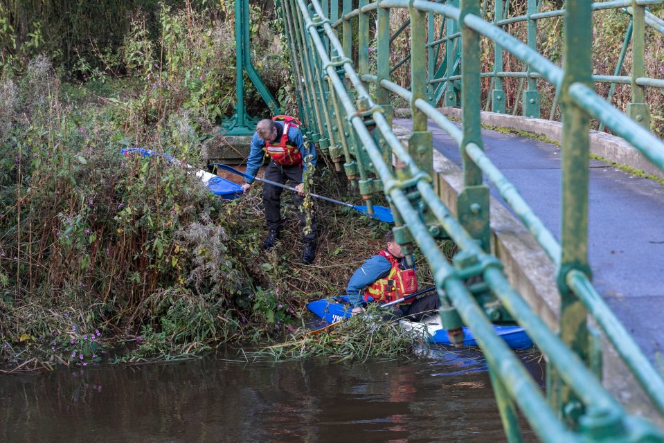 a man in a life jacket is standing next to a person in a kayak