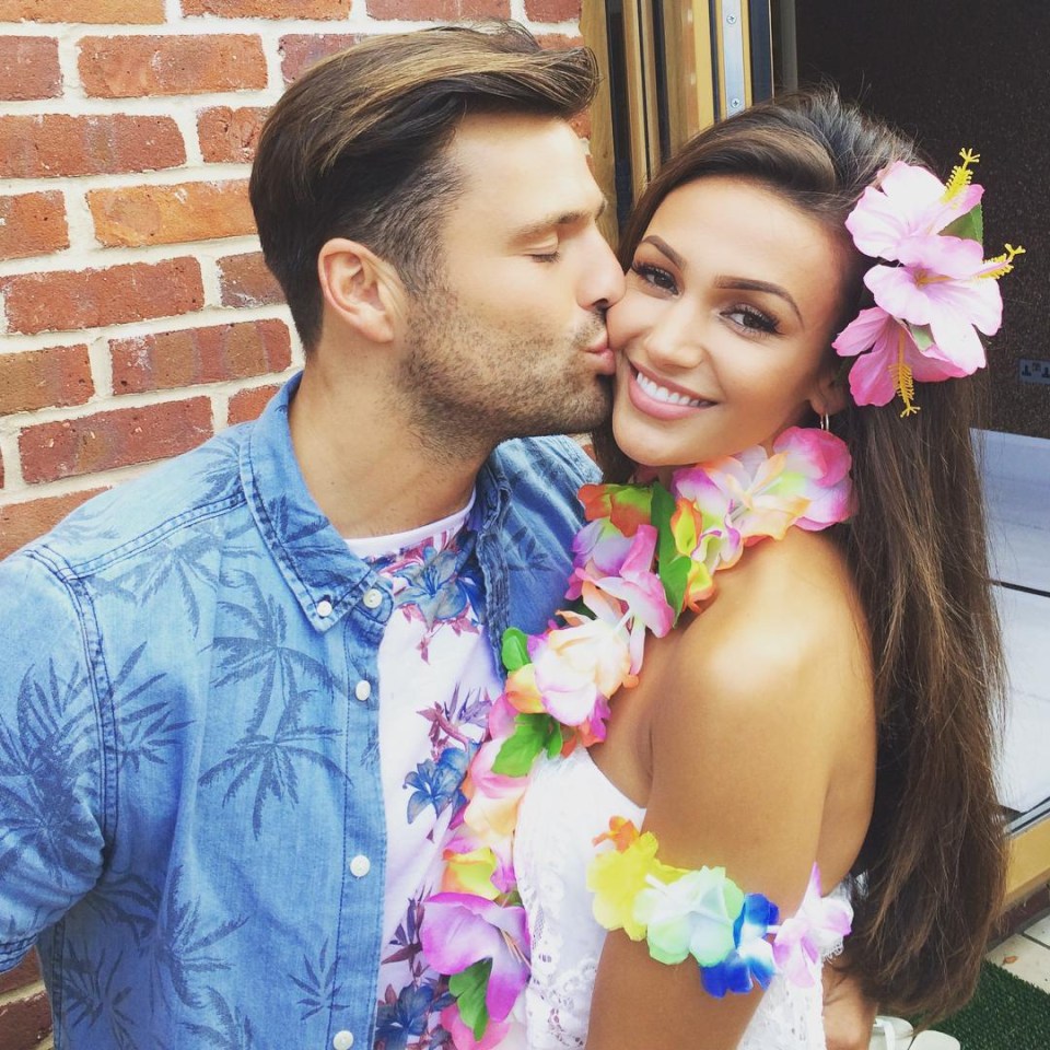 a man kisses a woman wearing flowers in her hair