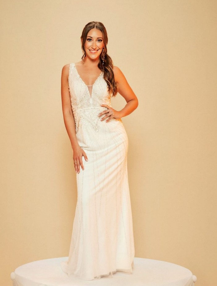 a woman in a white dress is standing on a pedestal