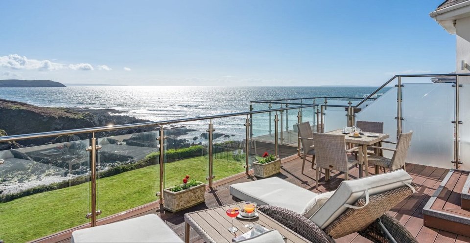 a balcony with a table and chairs overlooking the ocean