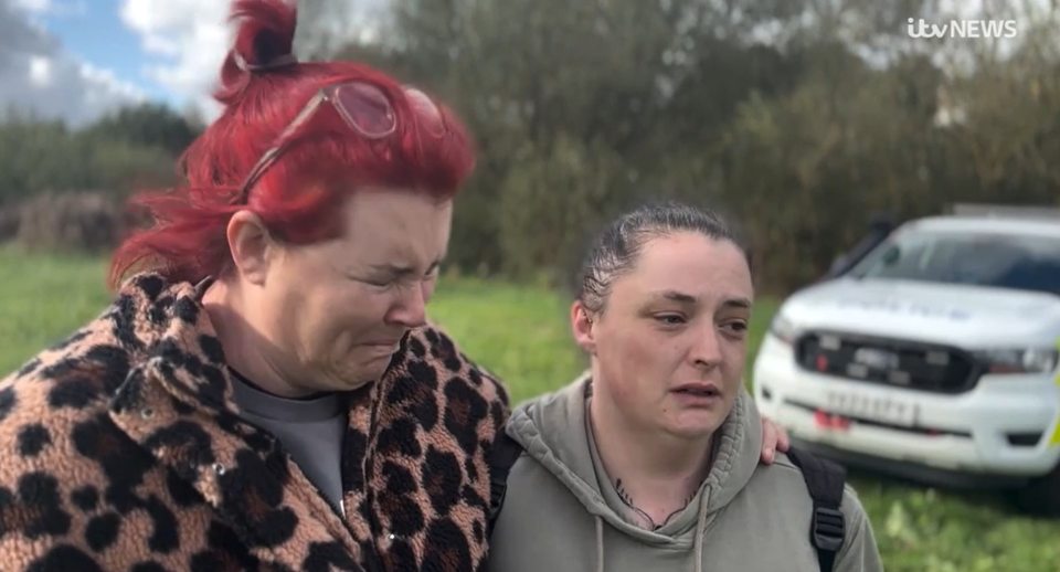 two women standing next to each other in front of a white van that says itv news