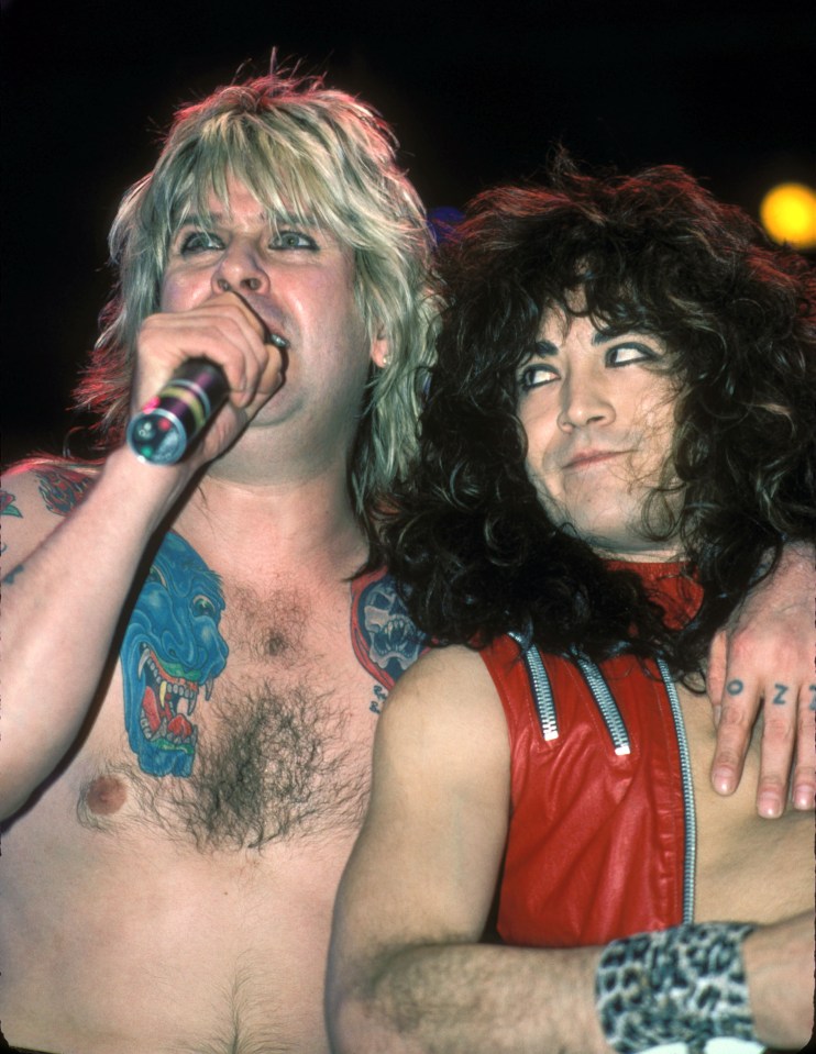 a man with a tattoo on his chest is singing into a microphone