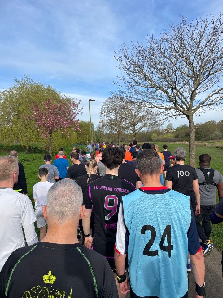 a man wearing a fc bayern munich jersey walks with others
