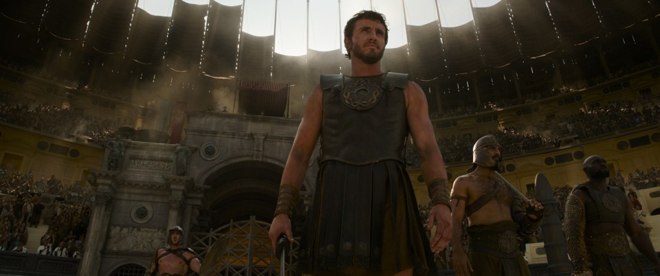 a man in a gladiator costume stands in front of a crowd