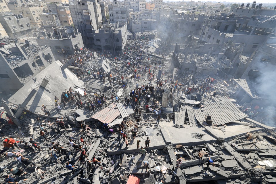 a large group of people are standing in the rubble of a building