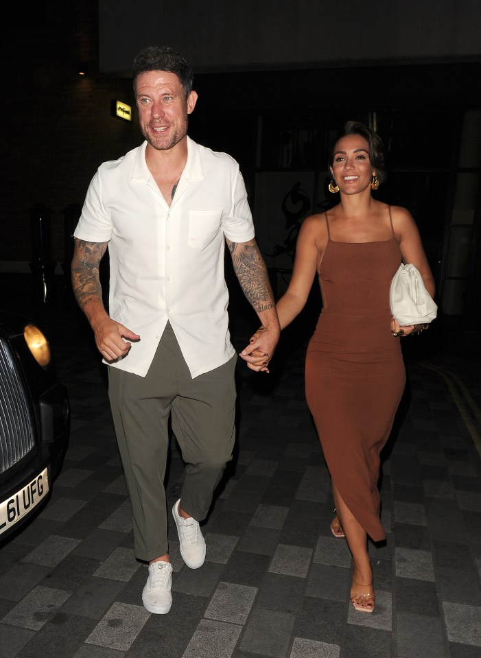 a man and a woman are walking down a street holding hands