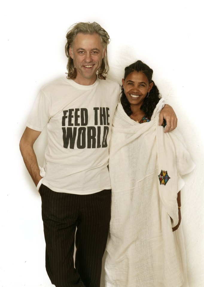 a man wearing a feed the world t-shirt stands next to a woman
