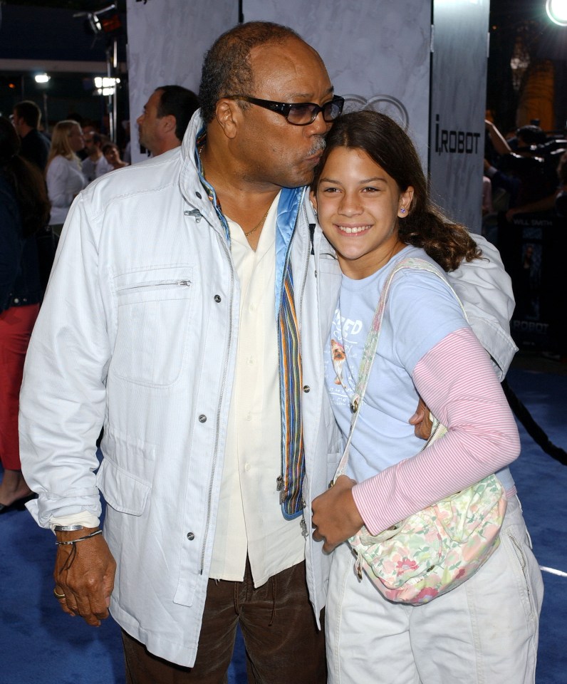 a man kisses a little girl on the cheek in front of an irobot sign