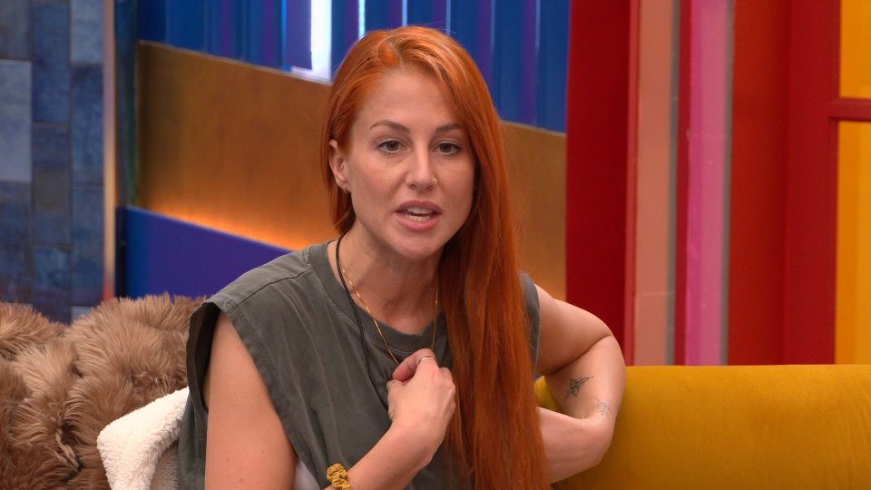 a woman with red hair is sitting on a yellow couch