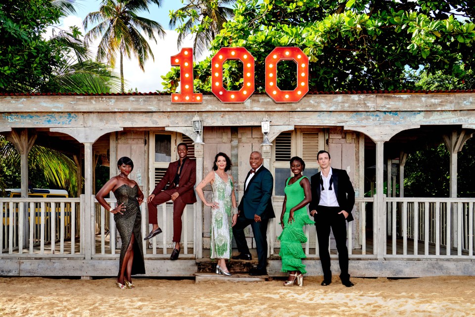 a group of people standing in front of a sign that says 100