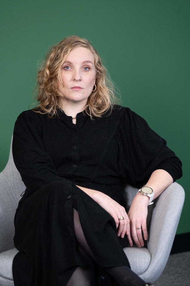 a woman in a black dress is sitting in a chair