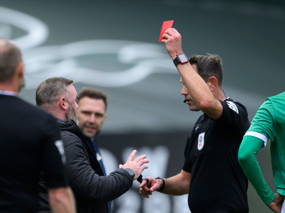a referee is giving a red card to a player