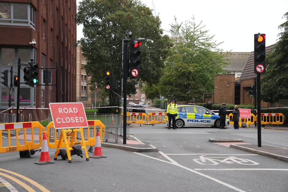 a police car is parked in front of a road closed sign