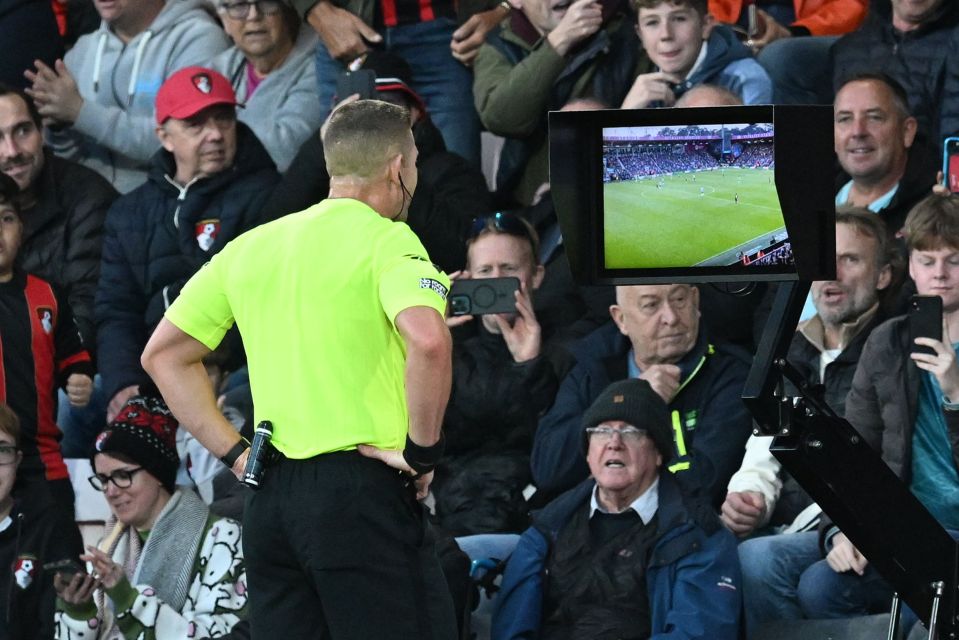 a referee is taking a picture of a soccer game