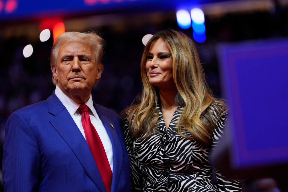 a man in a suit and tie stands next to a woman in a zebra print dress