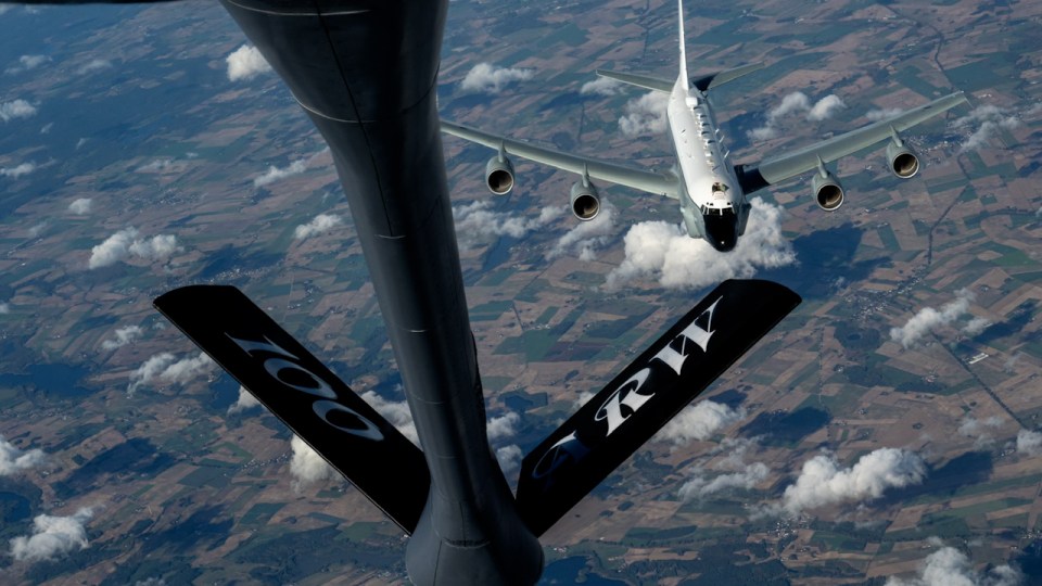 a plane is being refueled by a tanker that says rh on it