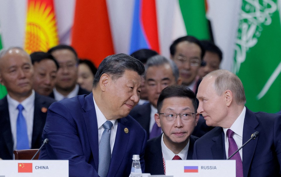 three men sit at a table with a sign that says china and russia