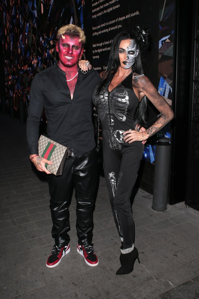 a woman in a skeleton costume stands next to a man with red face paint