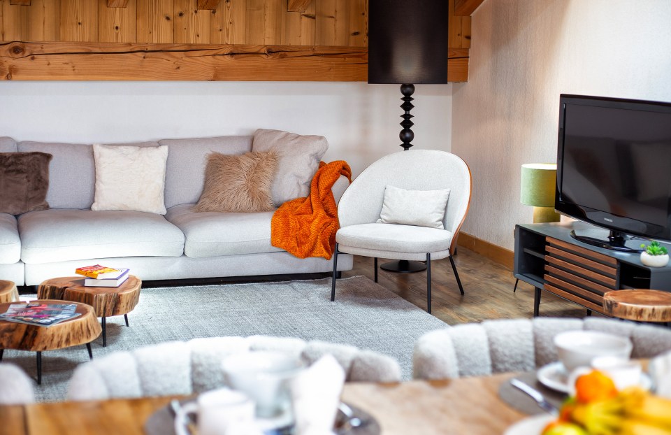 a living room with a couch a chair and a flat screen tv
