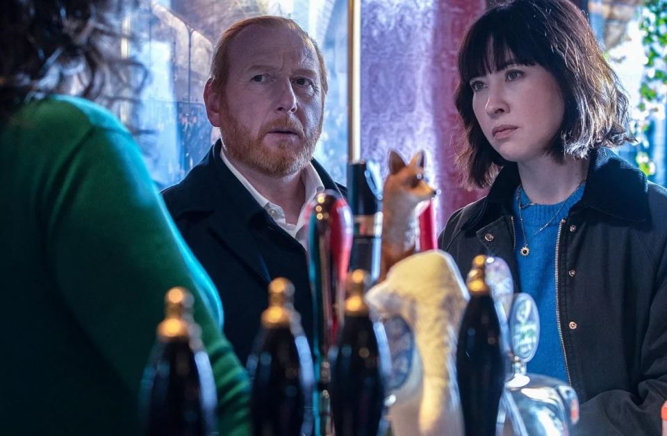 a man and a woman are standing in front of beer taps