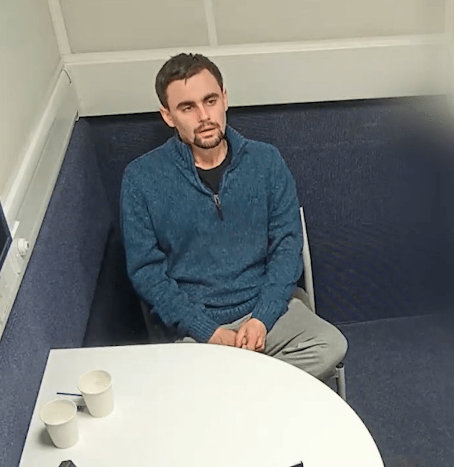 a man in a blue sweater sits at a table with two cups