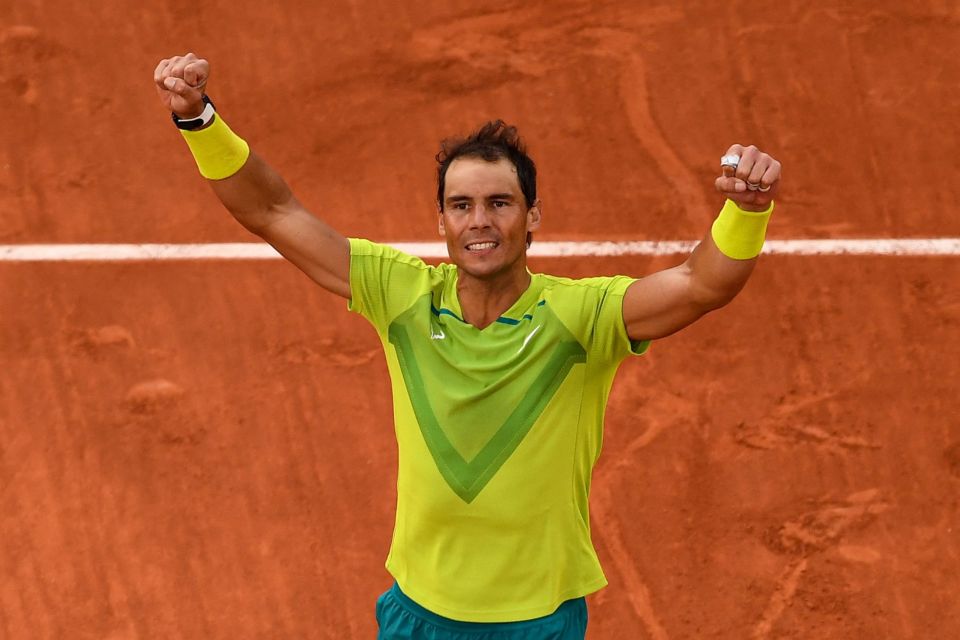 a man in a yellow shirt is raising his arms in the air