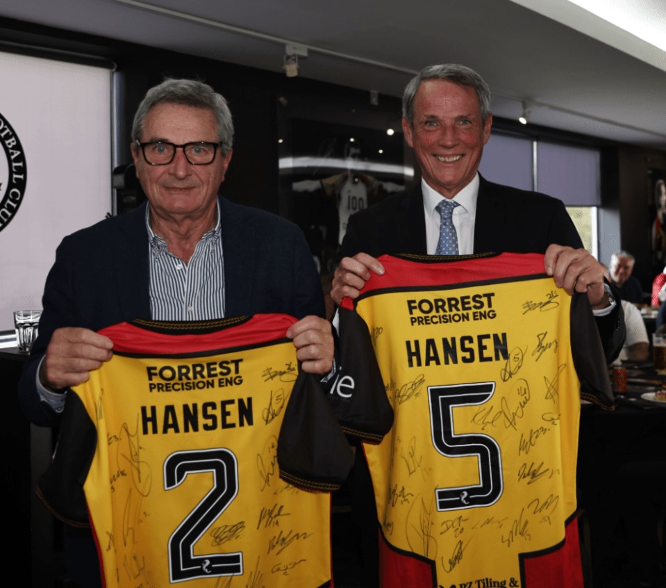 two men hold up jerseys that say forrest precision eng