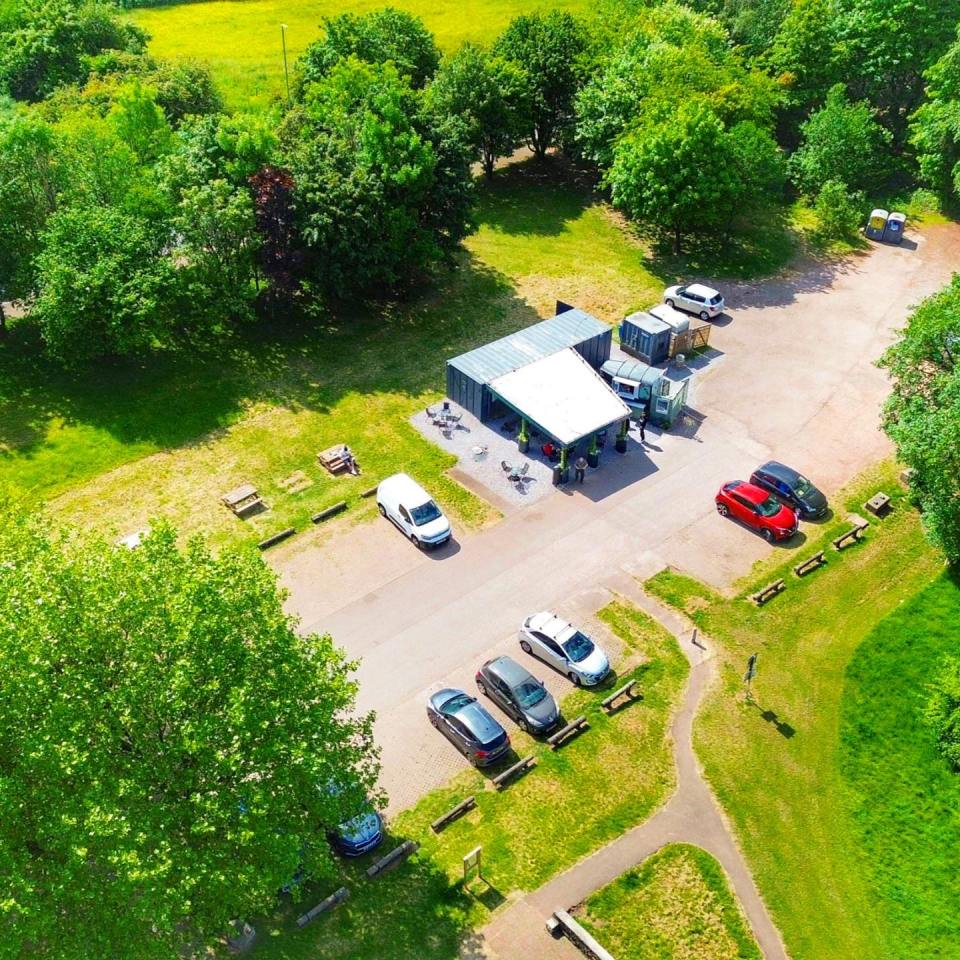 an aerial view of a parking lot with cars parked in front of a building