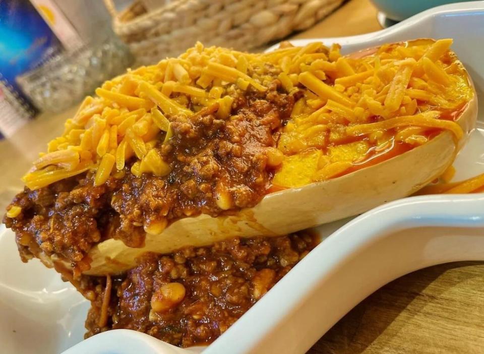 a squash filled with chili and cheese on a plate