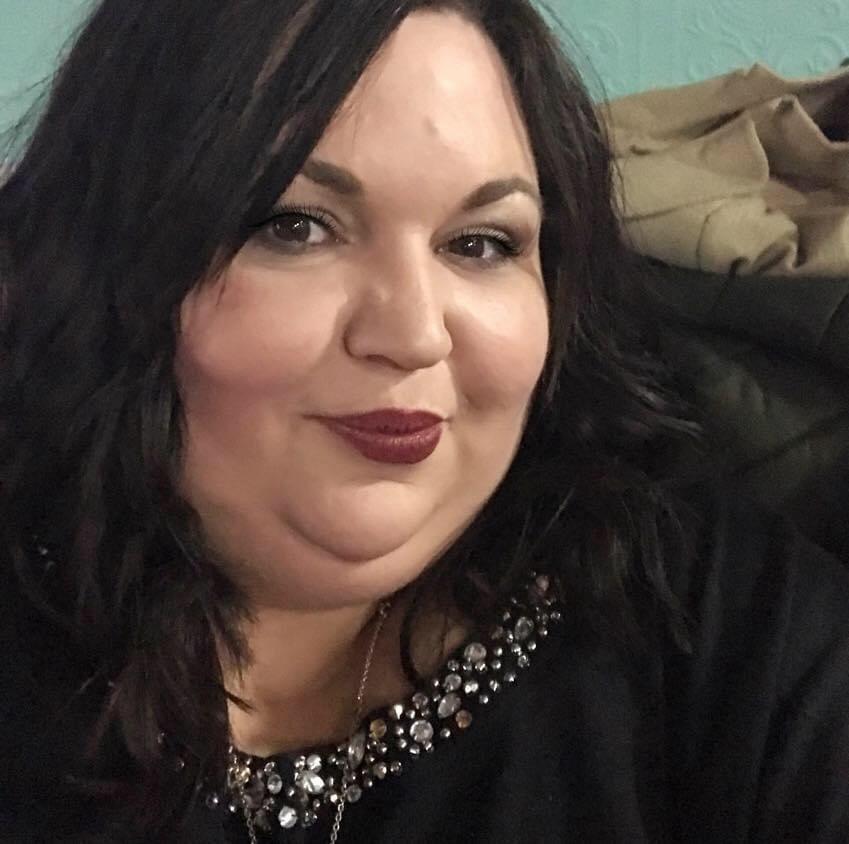 a woman wearing a black top with rhinestones on it