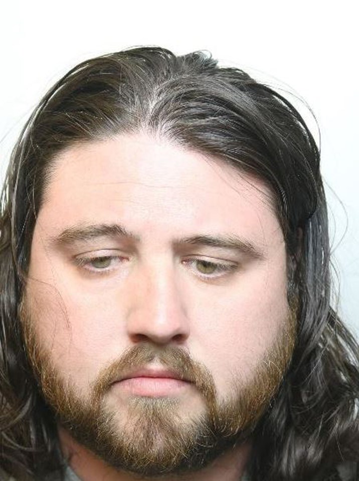 a man with long hair and a beard is looking at the camera .