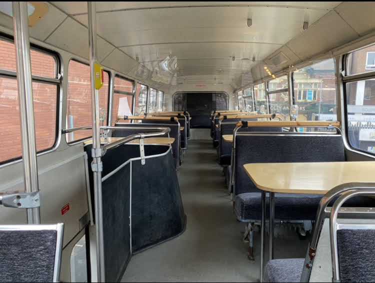 the inside of a bus with tables and seats