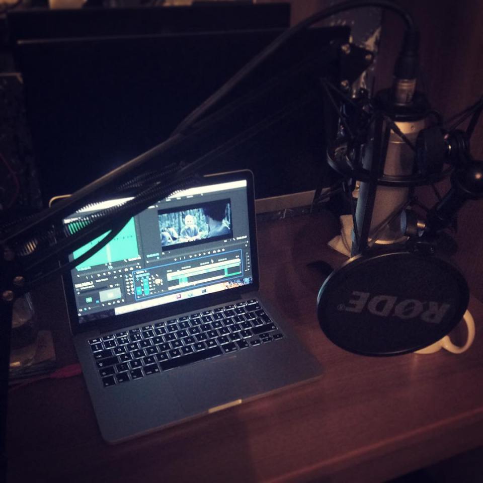 a rode microphone sits on a desk next to a laptop
