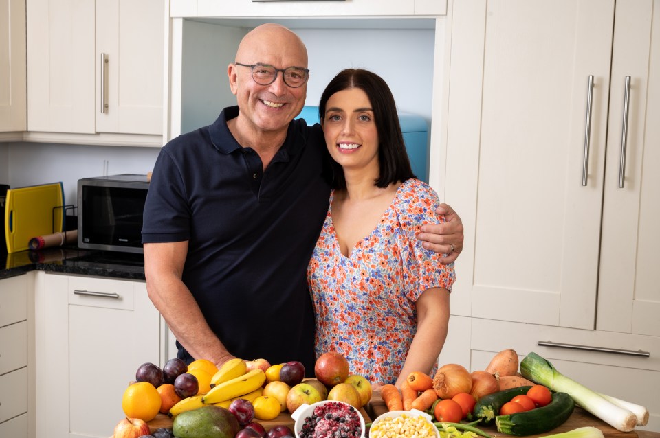a man and a woman standing in front of fruits and vegetables