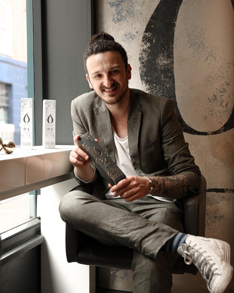 a man in a suit sits in front of two bottles of o.i.