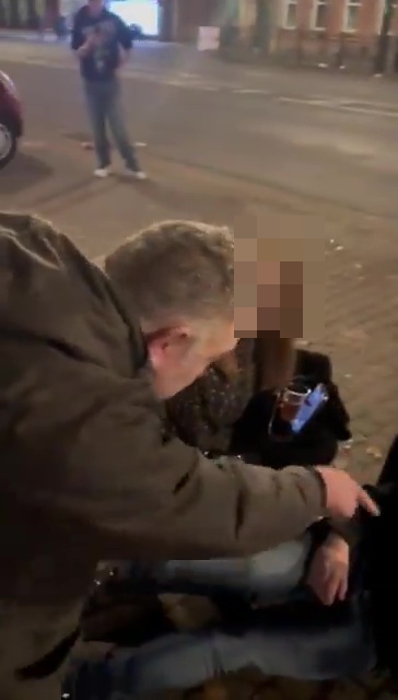 a man is pointing at a woman sitting on the ground .