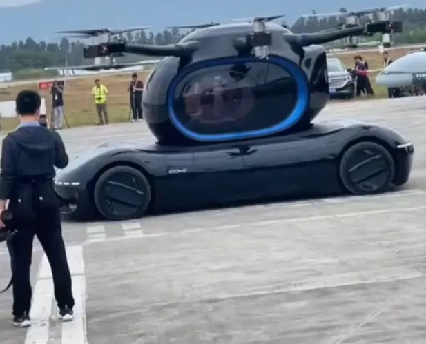 a man taking a picture of a car with a helicopter on top of it