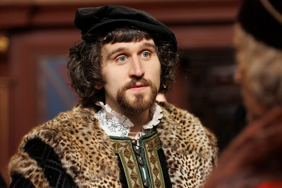 a man with a beard is wearing a fur coat