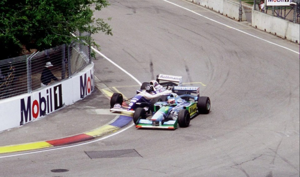 two racing cars on a track with a mobil sign in the background