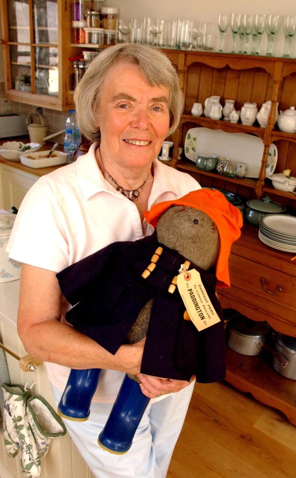 a woman is holding a stuffed animal that says paddington