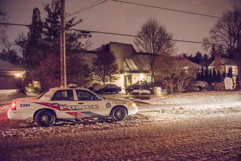 a large house is behind a yellow tape that says police line do not cross